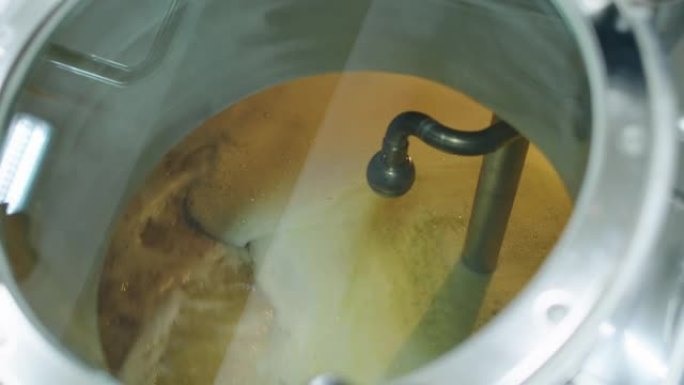 精酿啤酒厂的漩涡罐中的啤酒麦芽汁纺纱