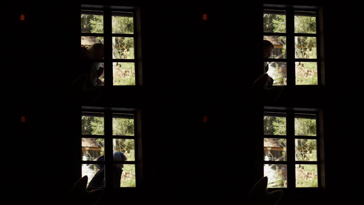 一个女孩从村里一所老房子的窗户往里看。一个女人敲门，看着窗外一间漆黑的房间。
