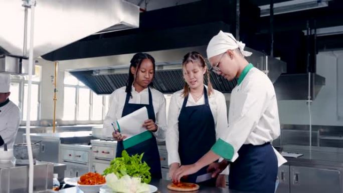 4K，亚非女生研究如何在厨房准备食材，而厨师为学生切茄子也回答了学生的问题，教切西红柿如何圆，漂亮，