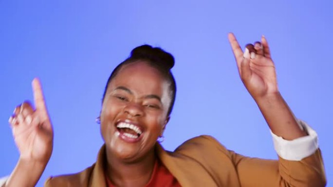 面对，跳舞和兴奋的黑人妇女在工作室在蓝色背景上的乐趣或自由。肖像，微笑和活力，快乐的非洲裔美国女性在