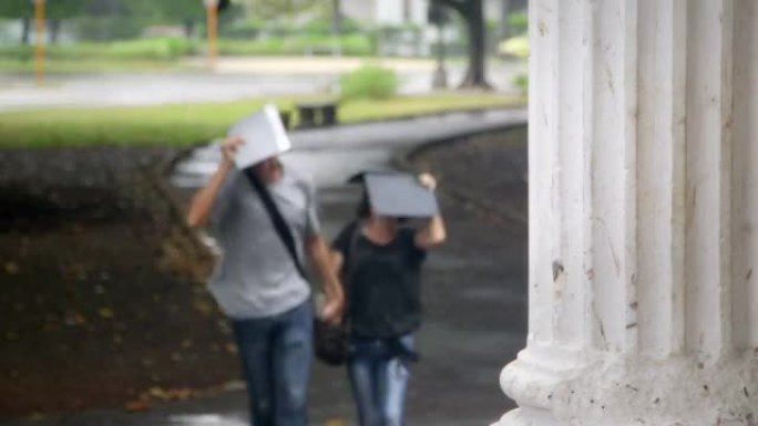 学生，男人和女人在暴风雨中奔跑