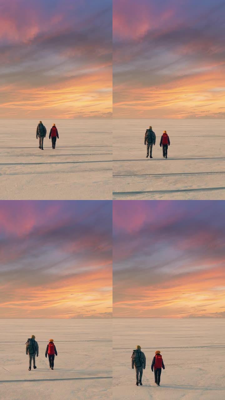 两个旅行者在冰冷的雪场中漫步