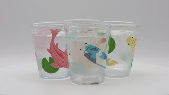 一组装饰有锦鲤鱼的小玻璃杯，当添加冷液体时，它们似乎可以算命。红色是爱，金色是幸运，蓝色是和平，白色