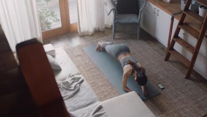 俯视图健康的亚洲女性在家锻炼，在客厅练习，享受早晨健身锻炼