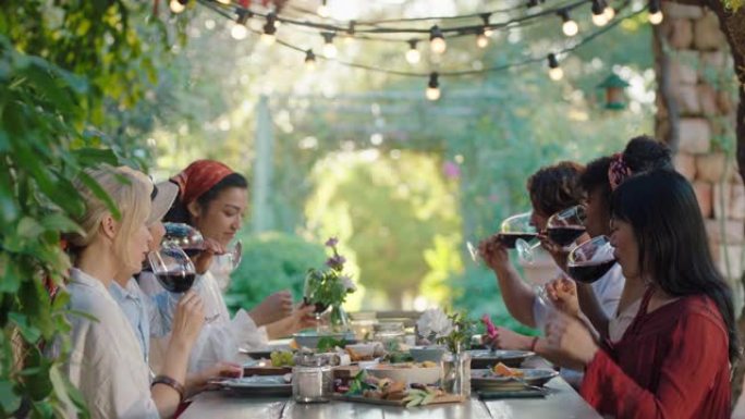 朋友敬酒庆祝晚宴喝酒吃地中海食物坐在餐桌旁享受美丽的夏日户外4k镜头