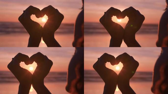 clsoe up女人双手做心形手势，手持美丽的日落耀斑，在海滩上享受浪漫的假期