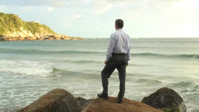 高清: 商人站在海上的一块岩石上