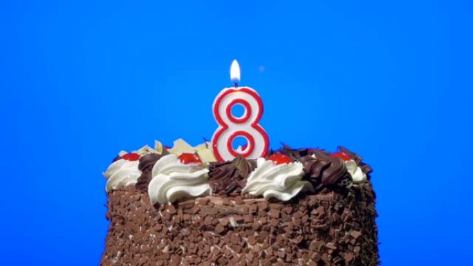 在美味的巧克力蛋糕上吹出八号生日蜡烛，蓝屏