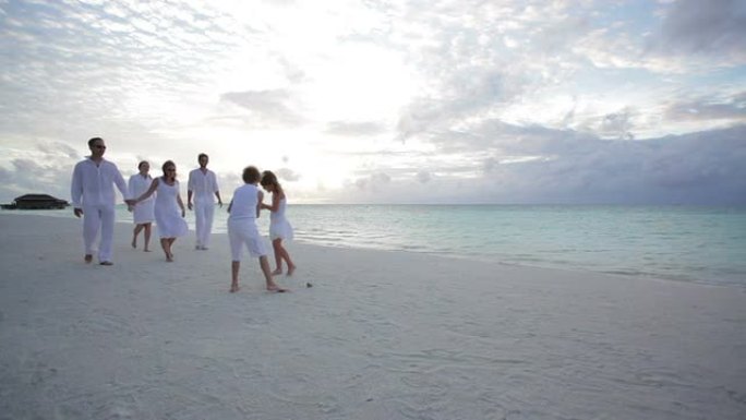 六口之家日落时在海滩上散步