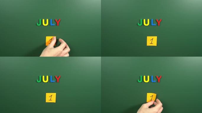 7月1日日历日用手在学校董事会上贴一张贴纸。1 7月日期。7月的第一天。第一个日期号。1天日历。一次