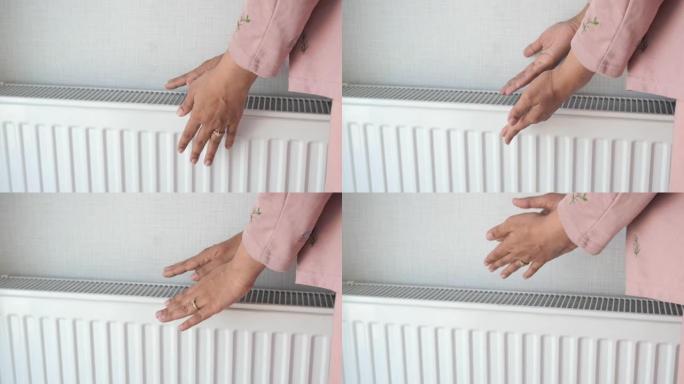 女人在家中电加热器附近暖手。
