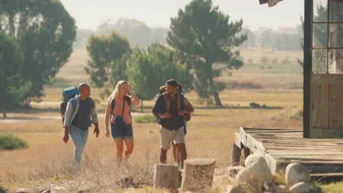 一群带背包的朋友一起在乡下徒步旅行