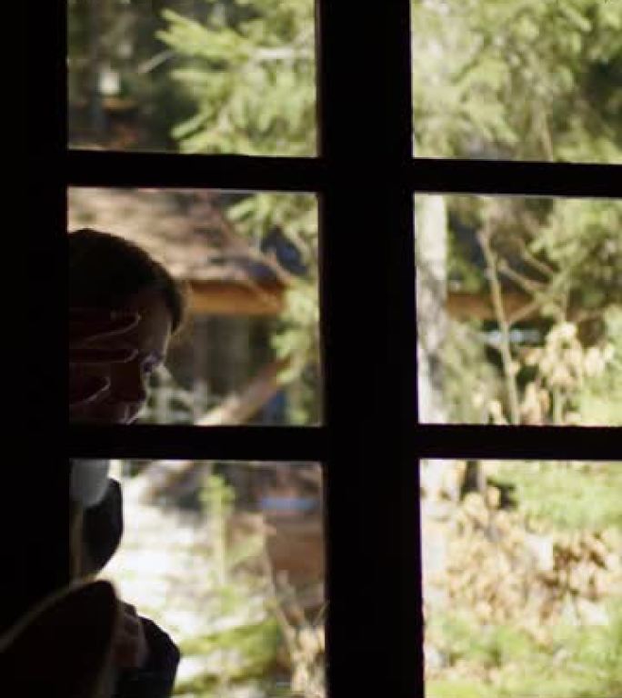 一个女孩从村里一所老房子的窗户往里看。一个女人敲门，看着窗外一间漆黑的房间。