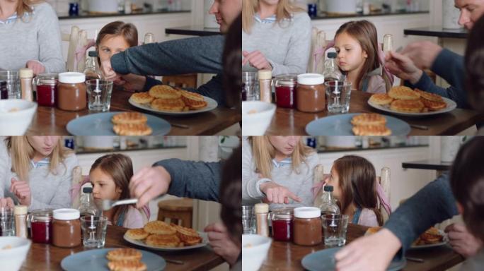 幸福的家庭吃早餐华夫饼，孩子们在家里的厨房享受美味佳肴