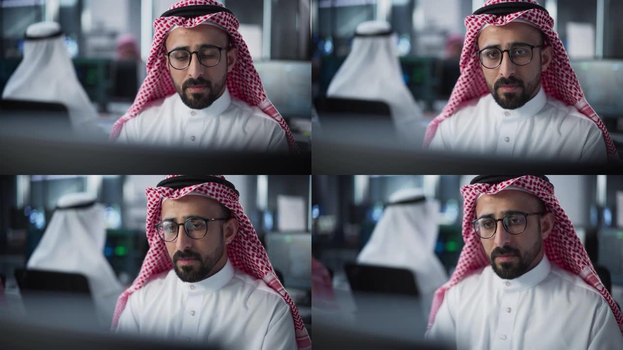 在技术办公环境中，一位中东工程师在台式计算机上工作的肖像。阿拉伯软件开发人员正在研究新的想法来解决技