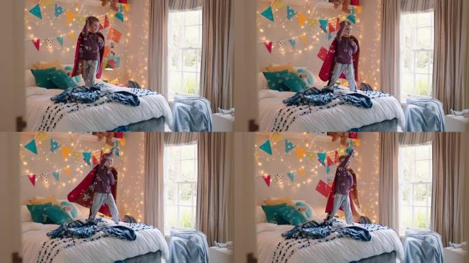 快乐的小男孩跳上床上穿着戏服玩玩具枪射击泡泡游戏在家里五颜六色的卧室享受嬉戏的想象