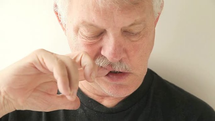 男人用手指清洁牙齿