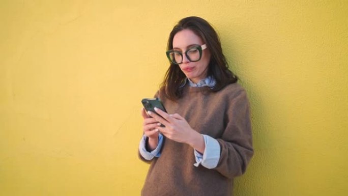 女人使用智能手机黄色背景