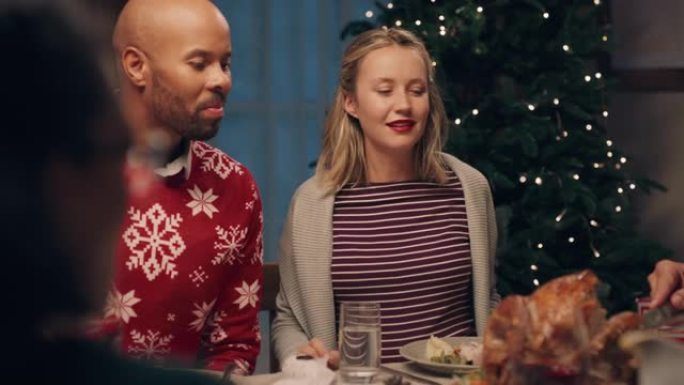快乐的多种族夫妇在圣诞晚宴上与朋友一起享受庆祝节日聊天在家分享晚餐4k