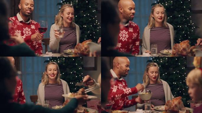 快乐的多种族夫妇在圣诞晚宴上与朋友一起享受庆祝节日聊天在家分享晚餐4k