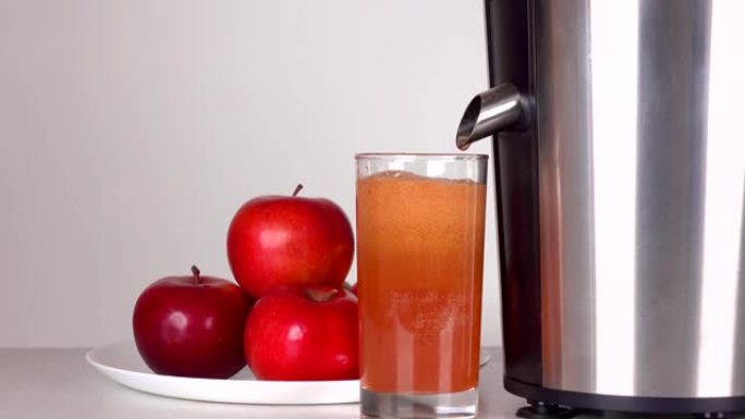 从榨汁机滴下的红苹果汁。全高清特写镜头