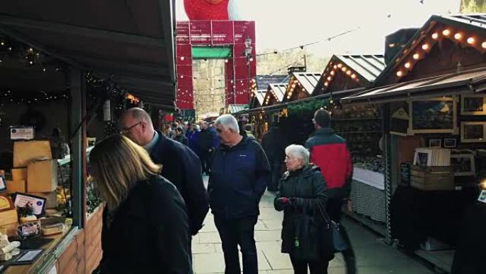 英国曼彻斯特-2016年12月16日。在阿尔伯特广场曼彻斯特市政厅前的圣诞市场上，购物者的照片。20