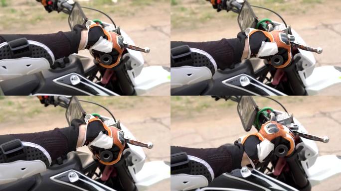用防护手套关闭男子的手转动摩托车上的油门踏板