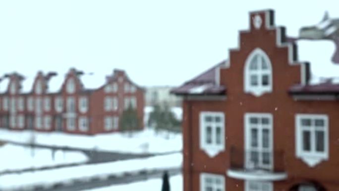 超级慢动作拍摄雪花落在模糊的红砖联排别墅