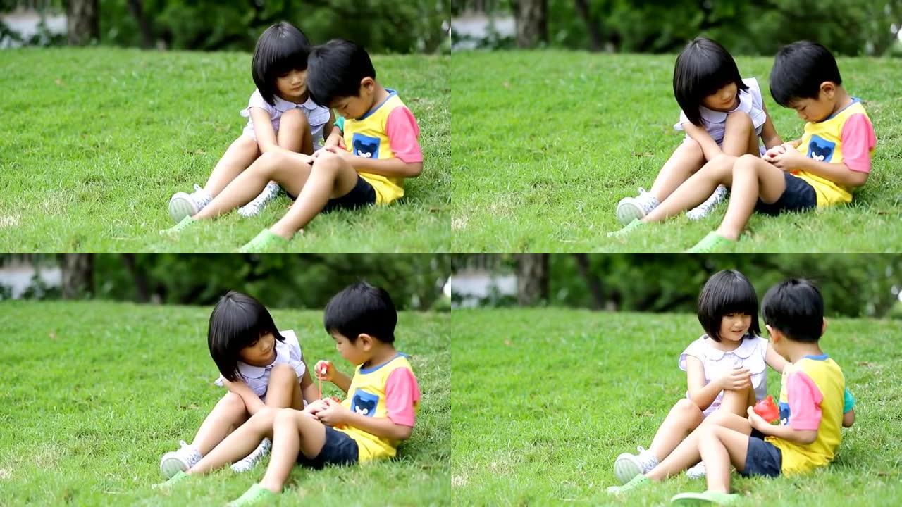 小亚洲男孩和女孩在公园吹肥皂泡