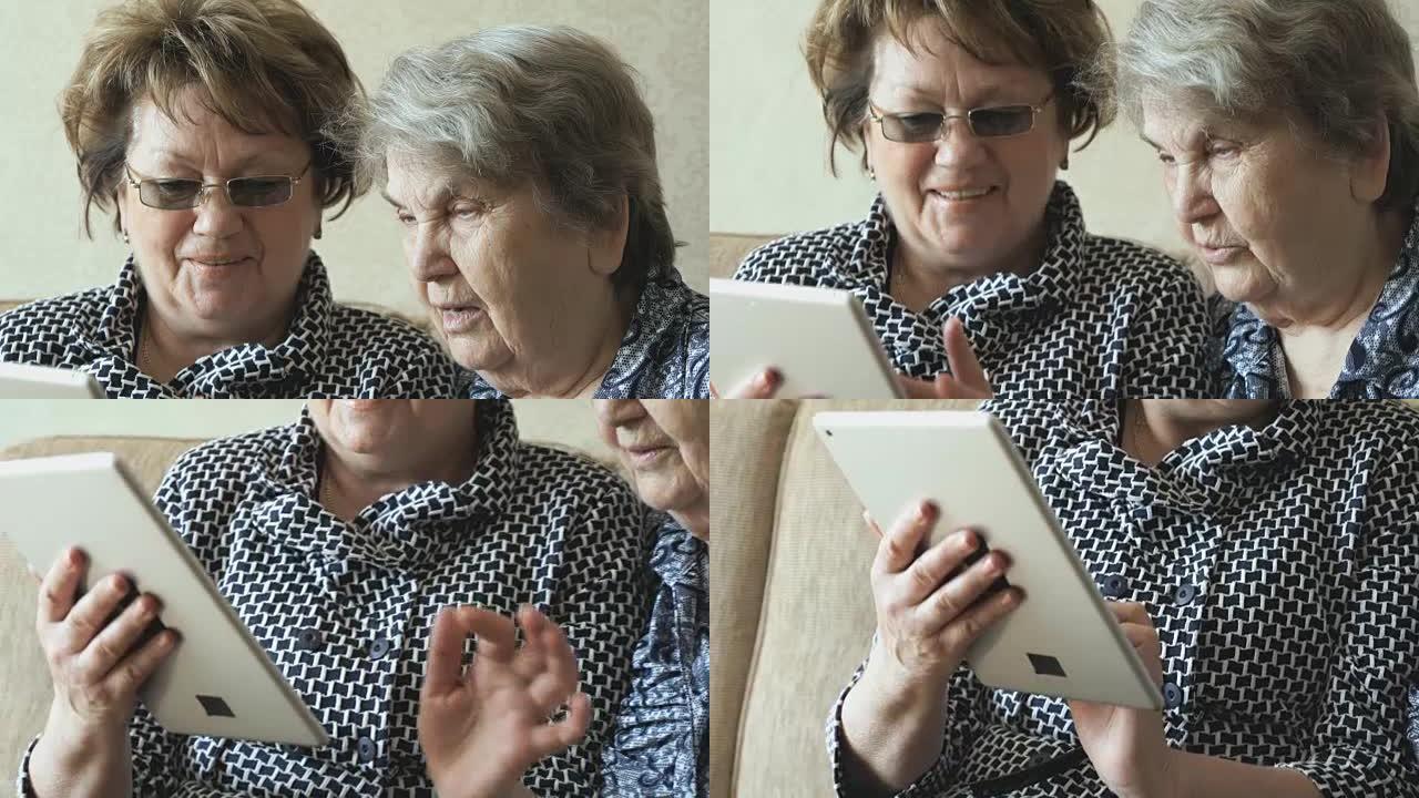 两名老年妇女使用平板电脑观看图片