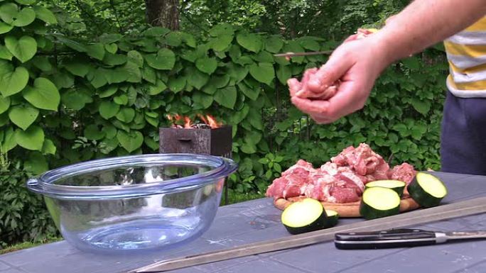 手刺伤肉和蔬菜块。烧烤中的火