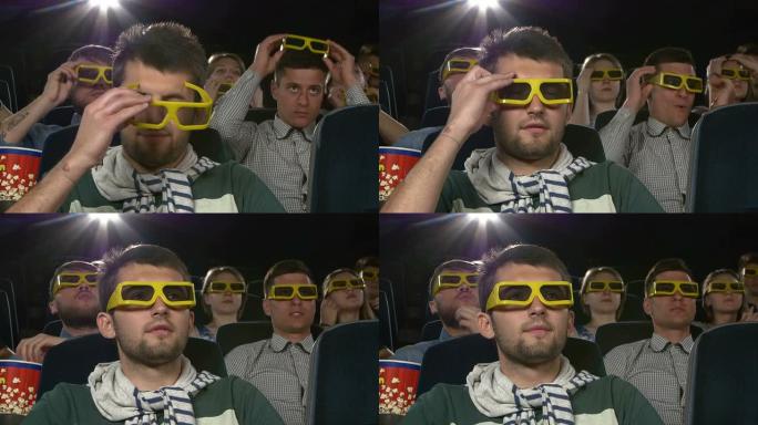 年轻人戴3D眼镜到电影院看电影