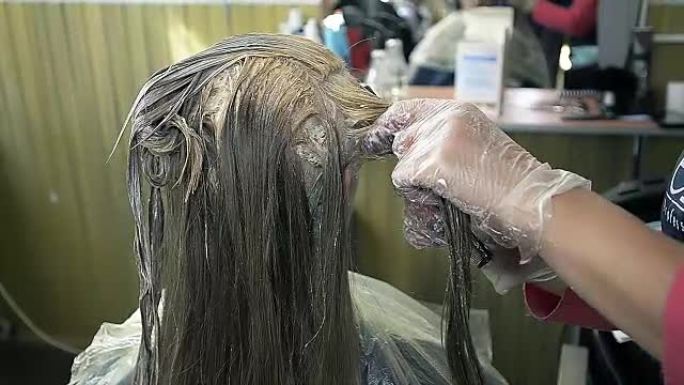 一个年轻女孩在美容院画画前梳理头发的特写