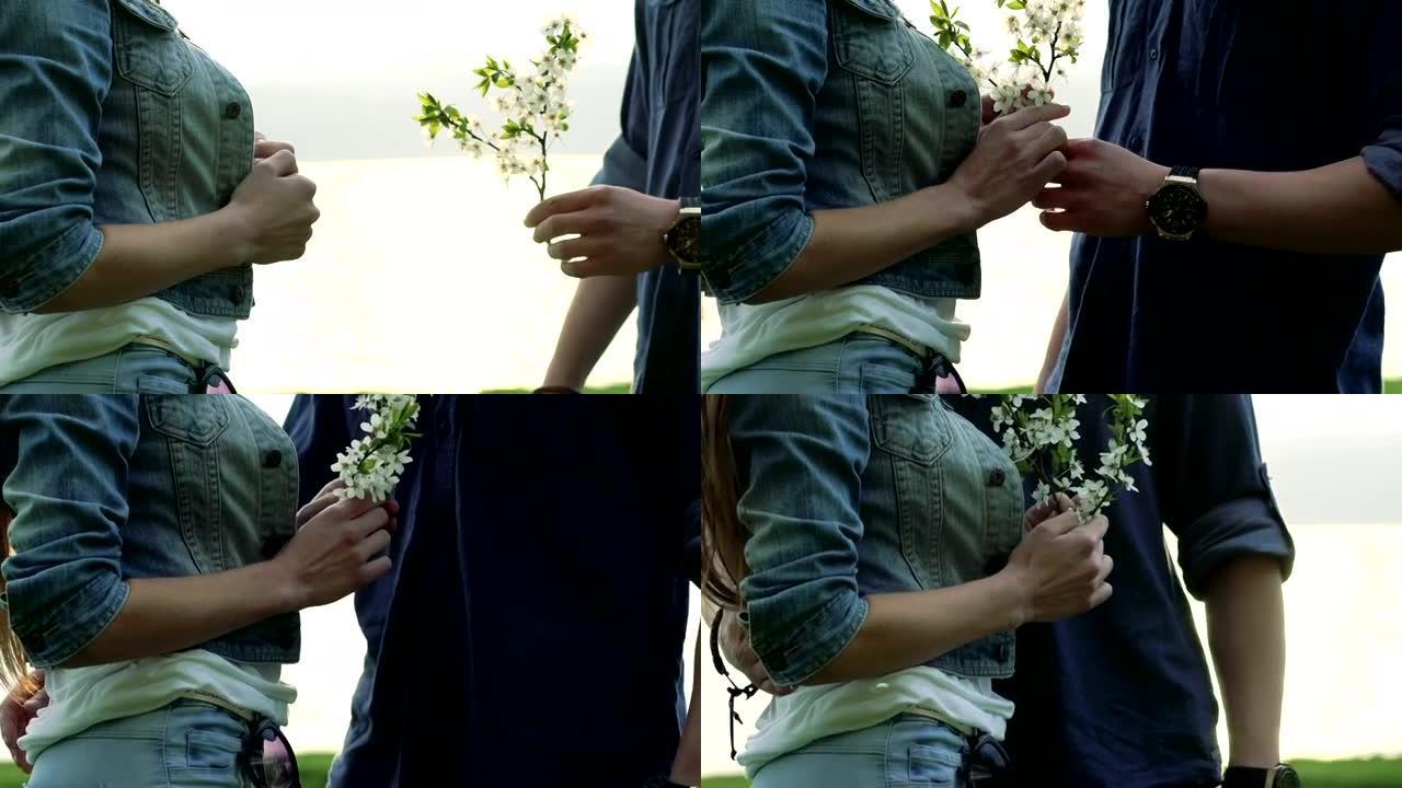 男孩的手给女孩开花并慢慢拥抱她的特写镜头