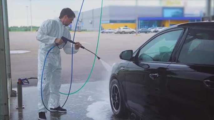 男人用水喷雾洗车。洗车自助服务。