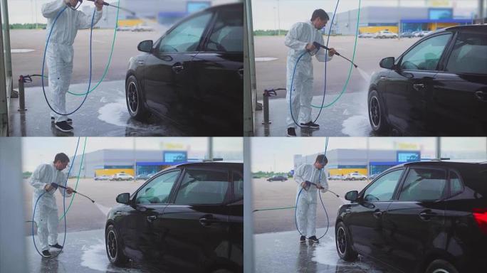 男人用水喷雾洗车。洗车自助服务。