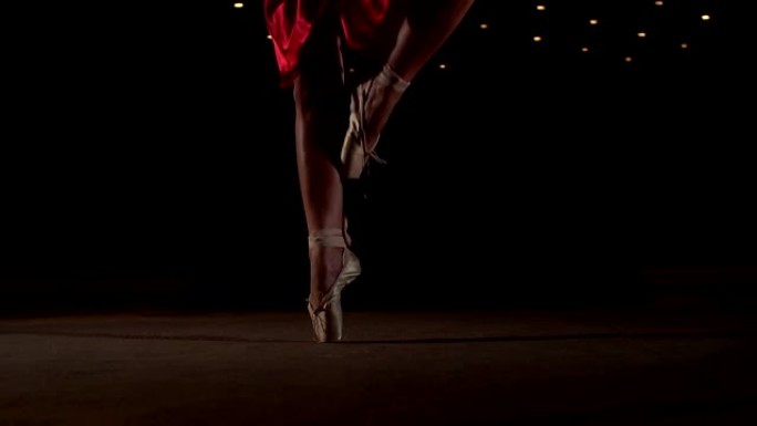 穿着足尖鞋的芭蕾舞演员在舞台上跳舞。