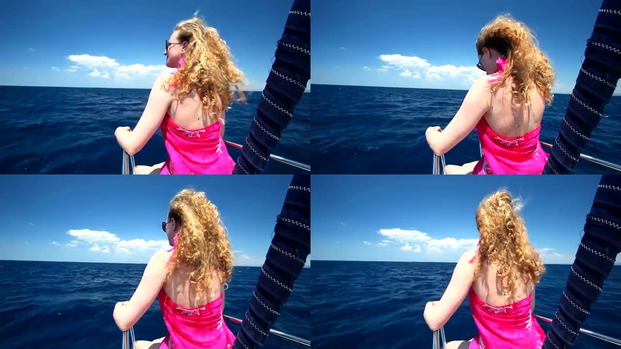 女人坐在帆船的船头上，欣赏海景