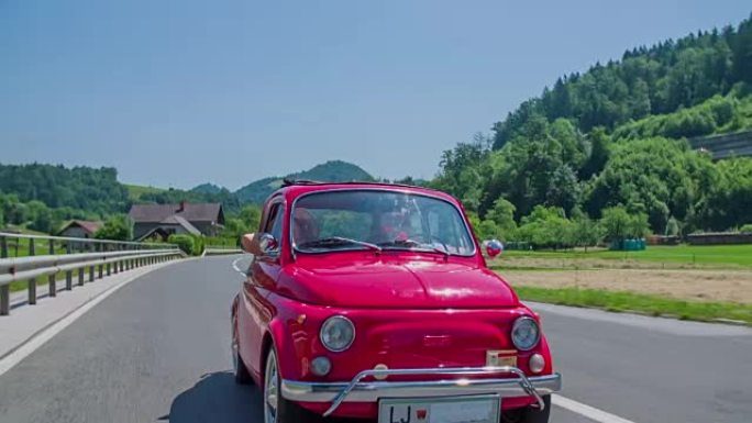 一对高年级夫妇在路过广告牌的道路上行驶