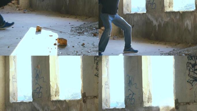 一个年轻人拿一块砖头扔进窗户。慢慢地