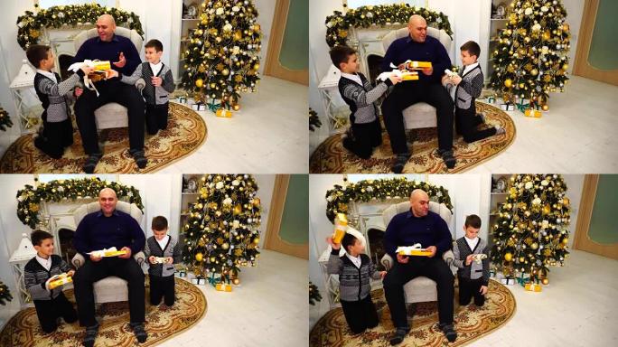 父亲和孩子们与双胞胎男孩交换礼物，欢笑在客厅的壁炉和高大的圣诞树装饰新年