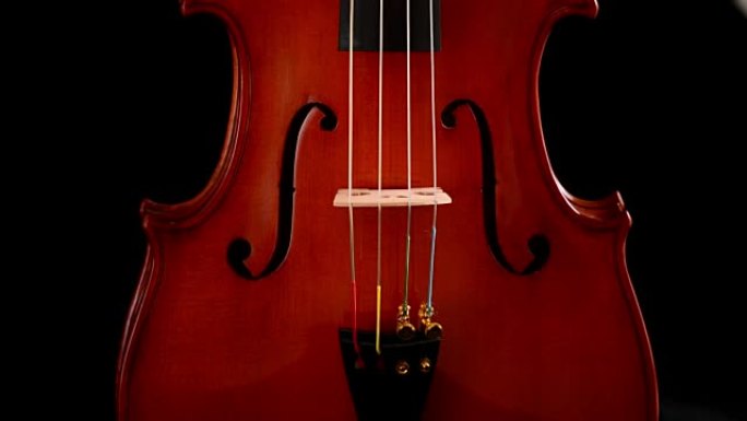 小提琴或中提琴乐器在黑色背景下转动