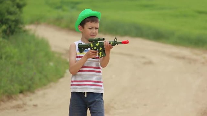 男孩拿着玩具枪在路上，一直在服役，守卫着