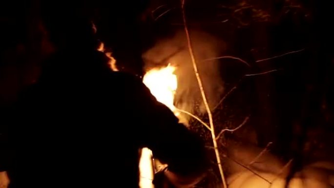 年轻人在冬天的森林里晚上带着火炬去