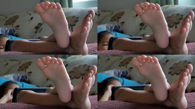 躺在家里沙发上的小女孩的脚和手指特写