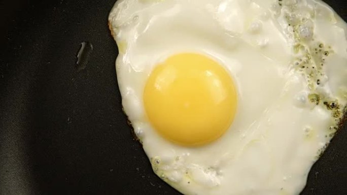 俯视图: 跟踪锅上煎鸡蛋的特写镜头