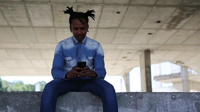 非洲男性放松和使用他的手机