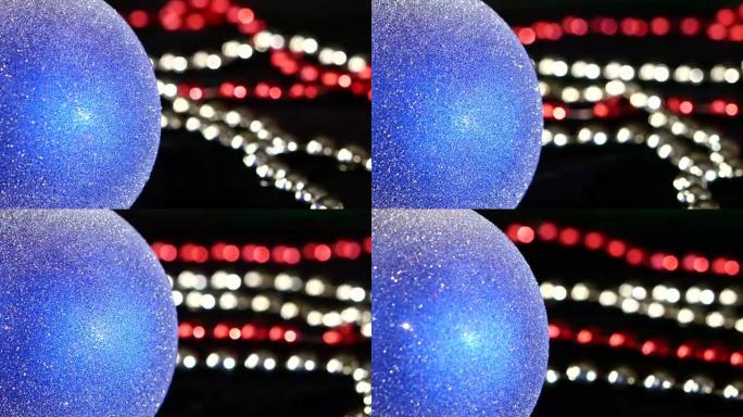 圣诞节或新年的闪亮蓝色玩具和珠子，旋转，红色和绿色，特写