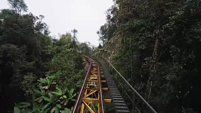 移动的旅客列车通过山区的森林铁路行驶。