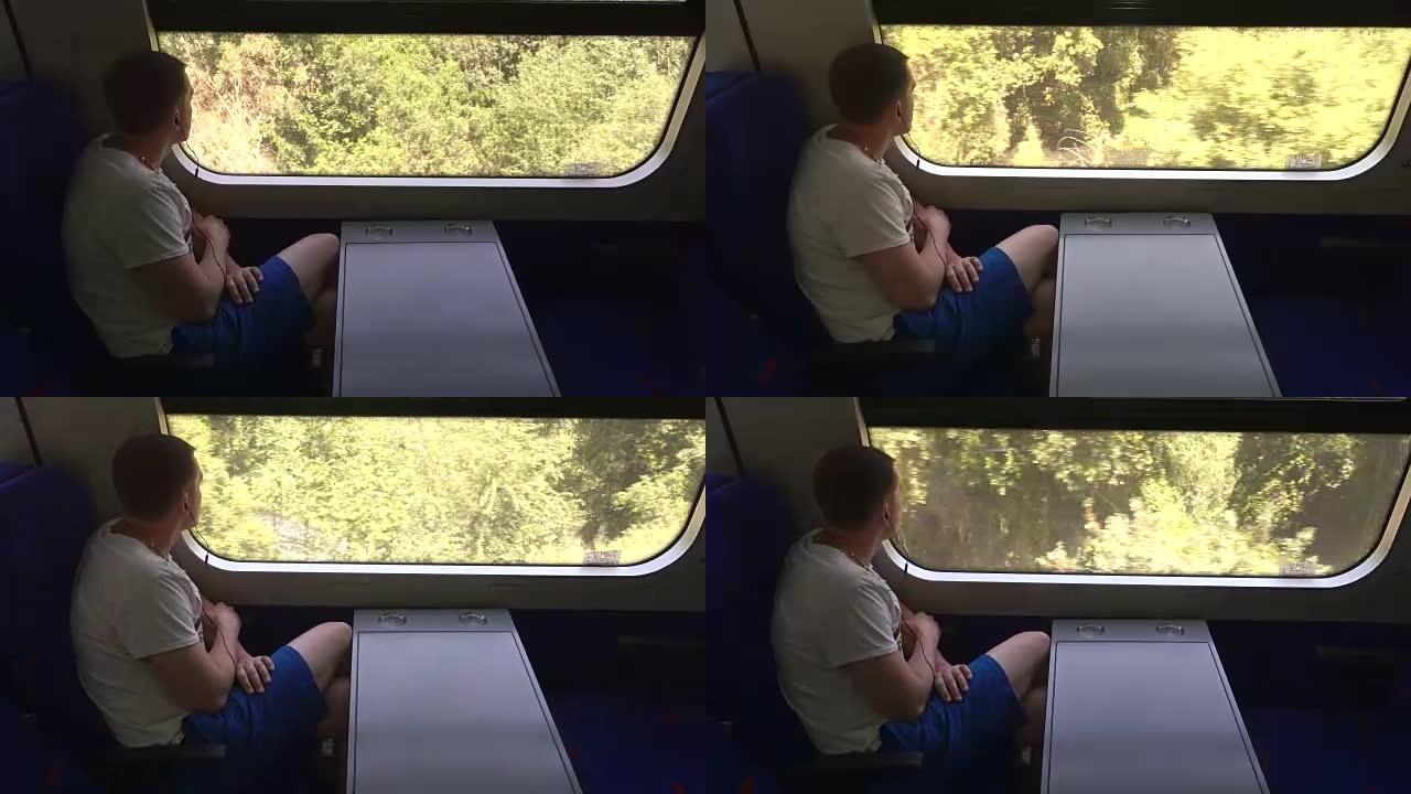 戴着耳机的年轻人看着窗外的火车